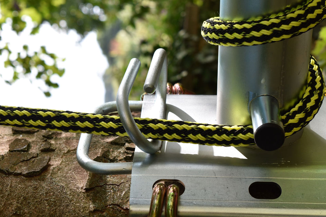 Hefty Flex 19mm yellow and black arborist climbing rope coiled on galvanised rope storage hooks mounted to tree